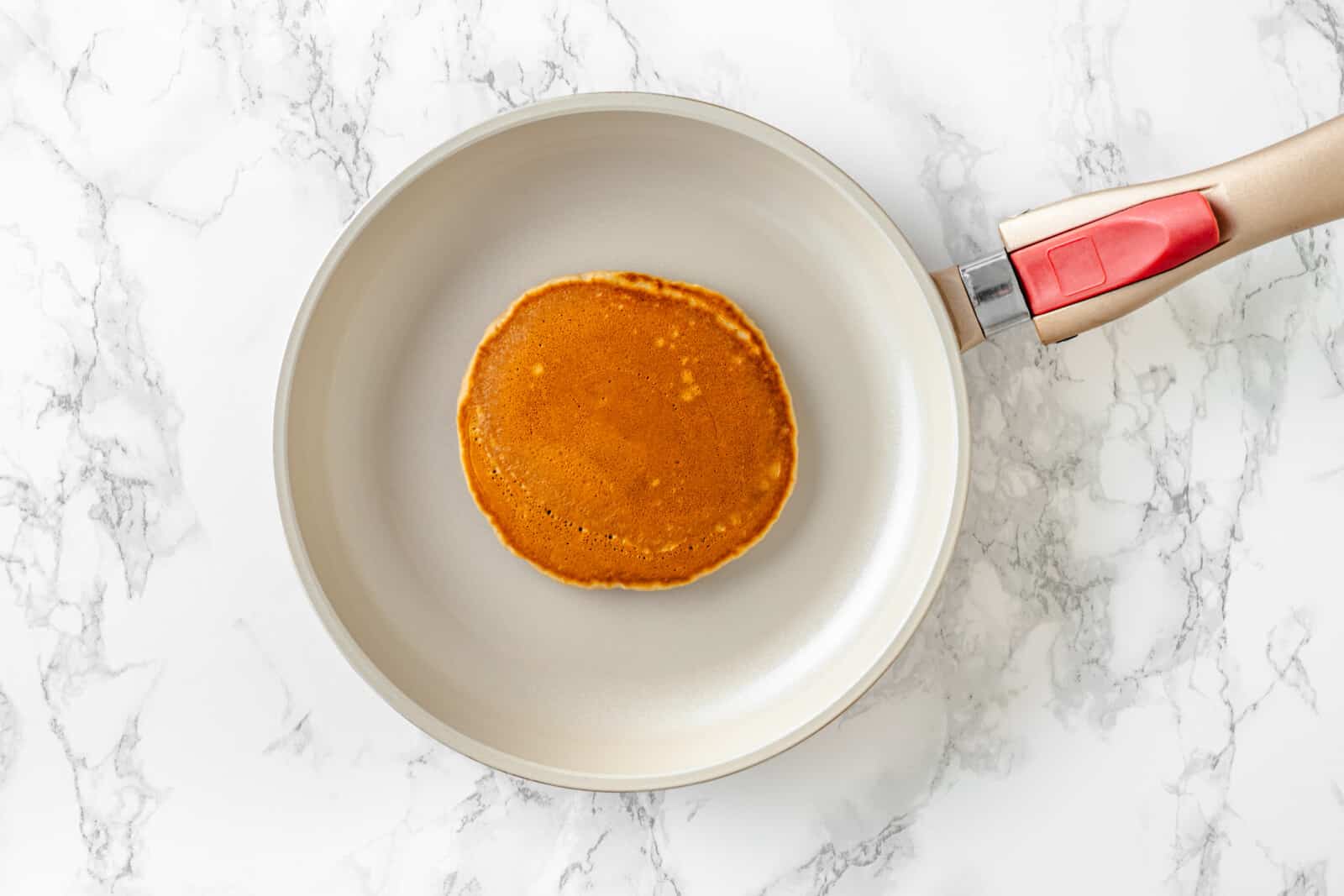 cooked pancake on a skittle with a white marbled background