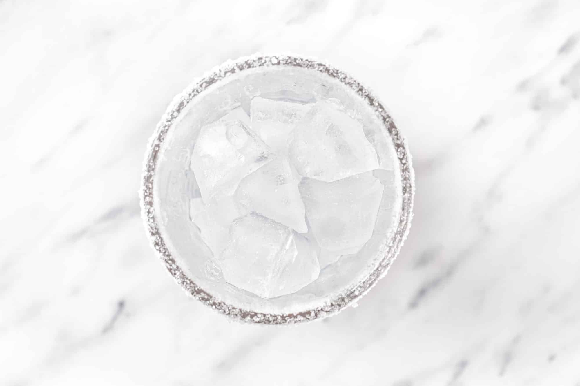 ice in a glass with sugar on the rim.