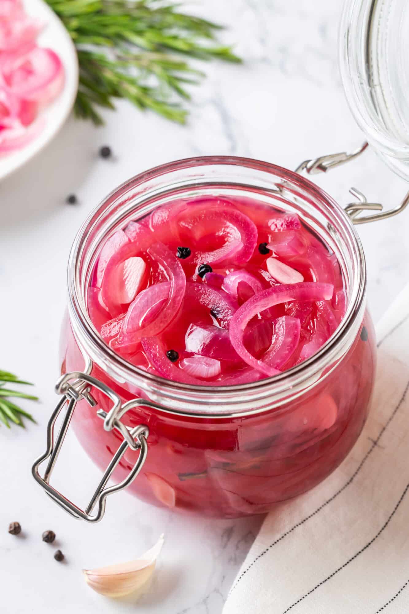 Pickled onions in a glass jar with a lid.