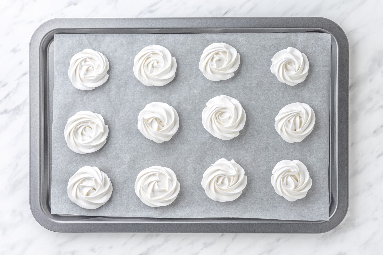 Piped marshmallows on a baking sheet.