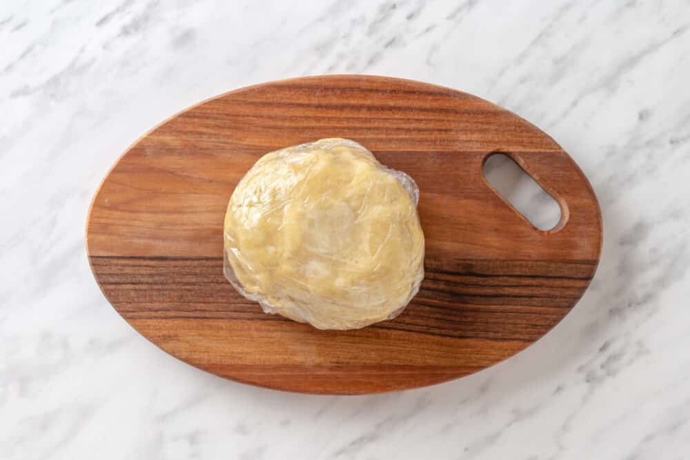 Pumpkin pie dough on a wooden board.