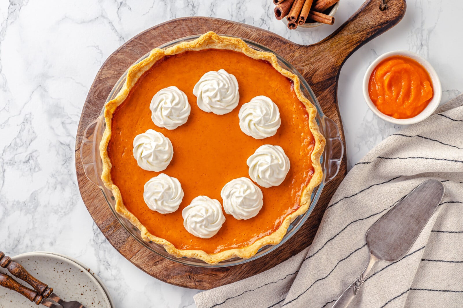 Pumpkin pie ready to serve on a wooden board.