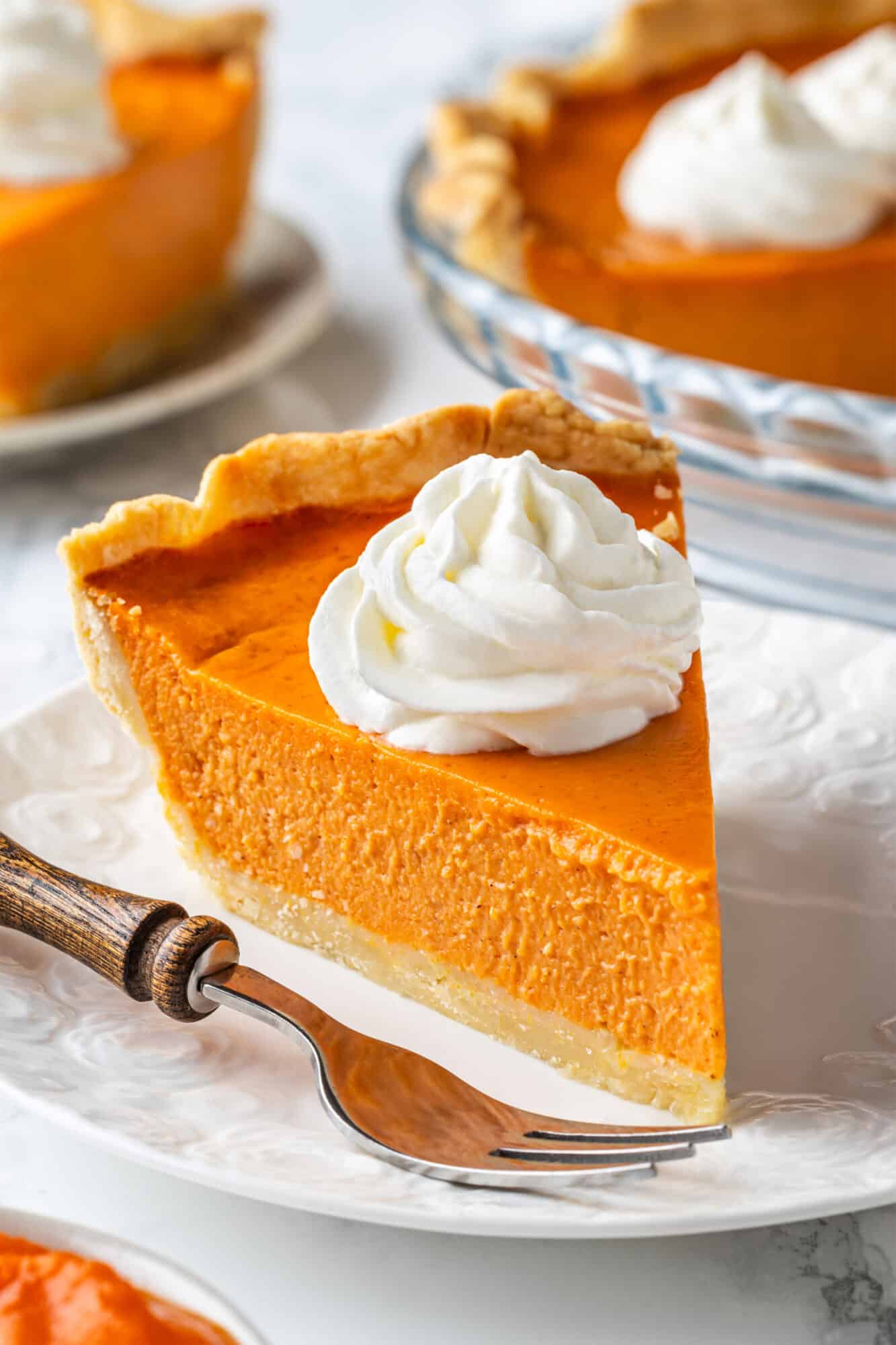 Pumpkin pie slice on a plate.