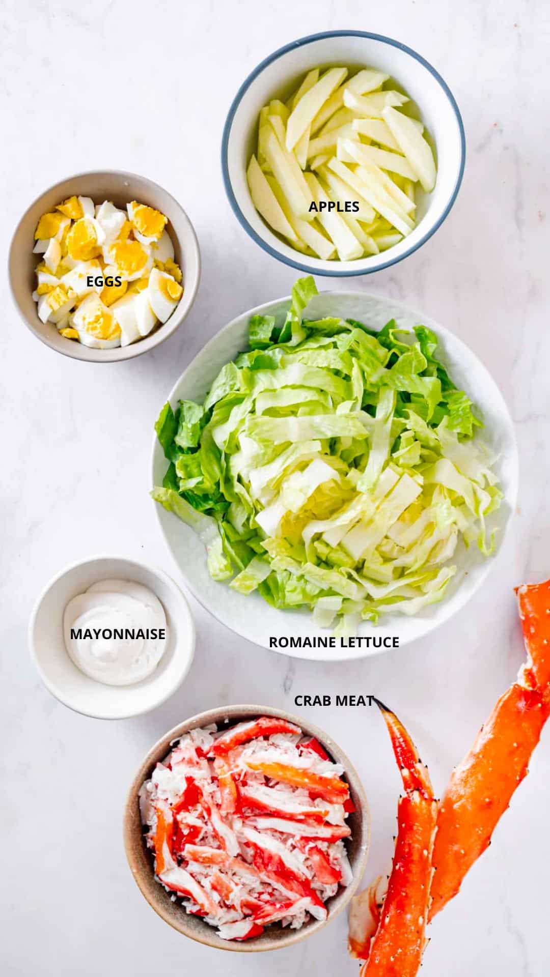 Crab and apple salad ingredients spread- apples, eggs, romaine lettuce, mayonnaise, and crab meat.