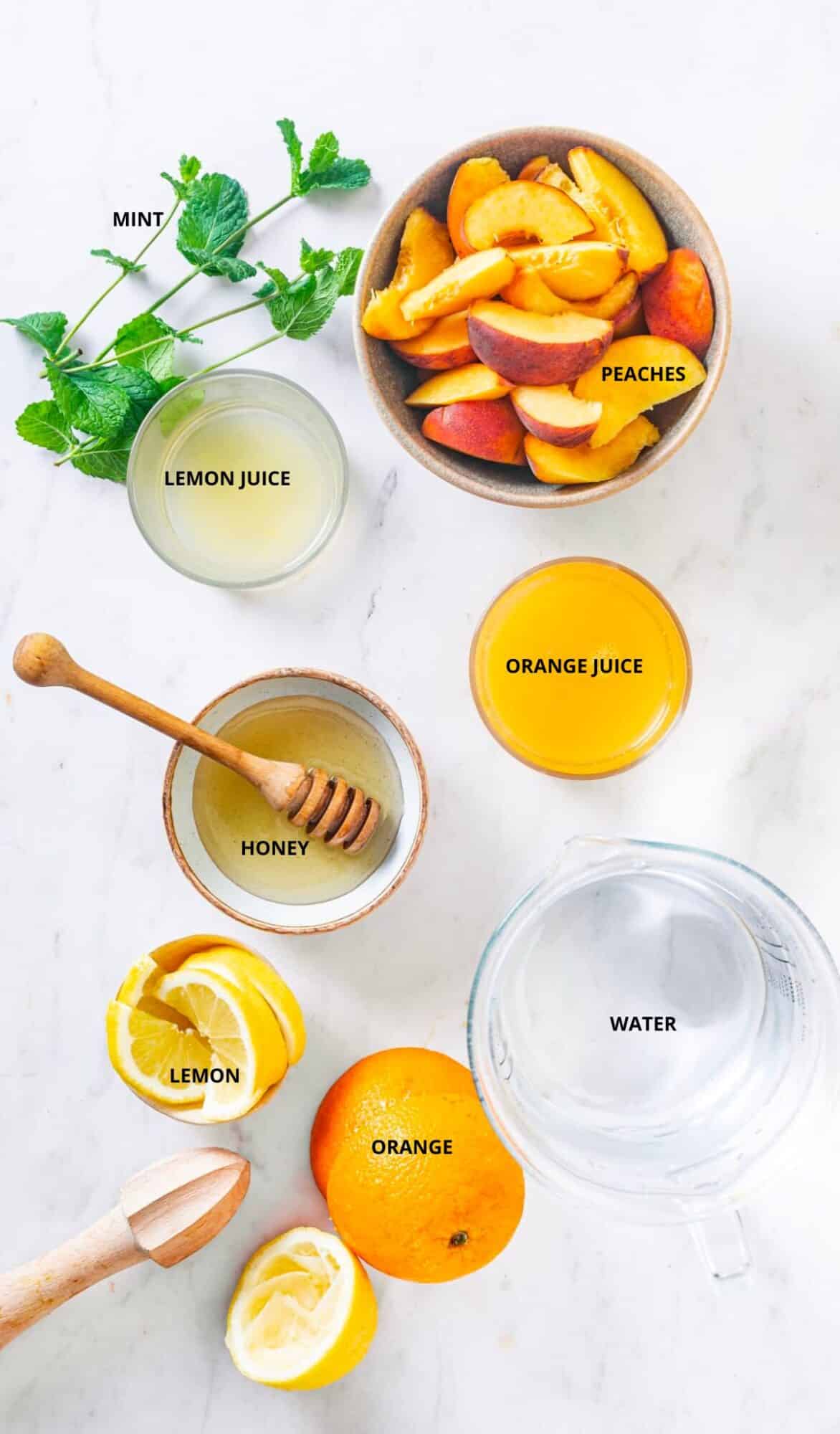 Peach lemonade ingredients spread with tags- peaches, mint, lemon juice, honey, lemon, orange, and water.