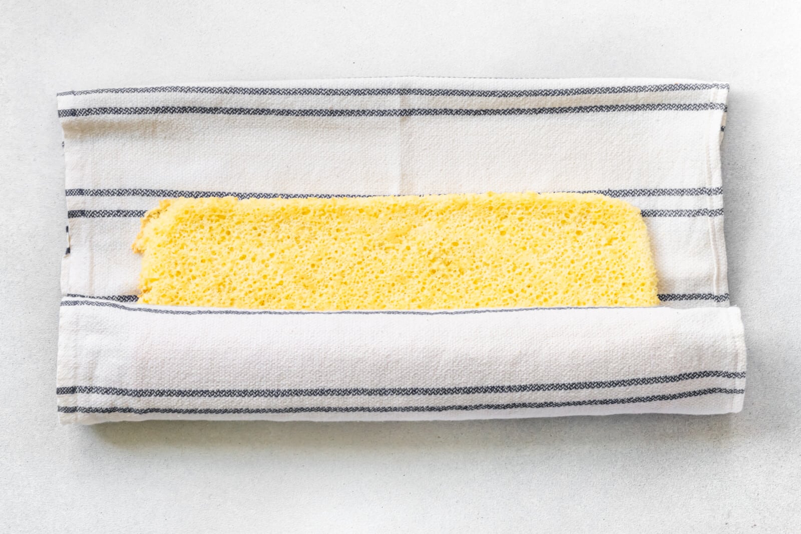 Rolling baked cake in a kitchen towel.