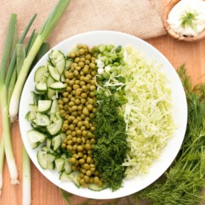 cabbage-salad-on-a-white-plate-with-greens-around