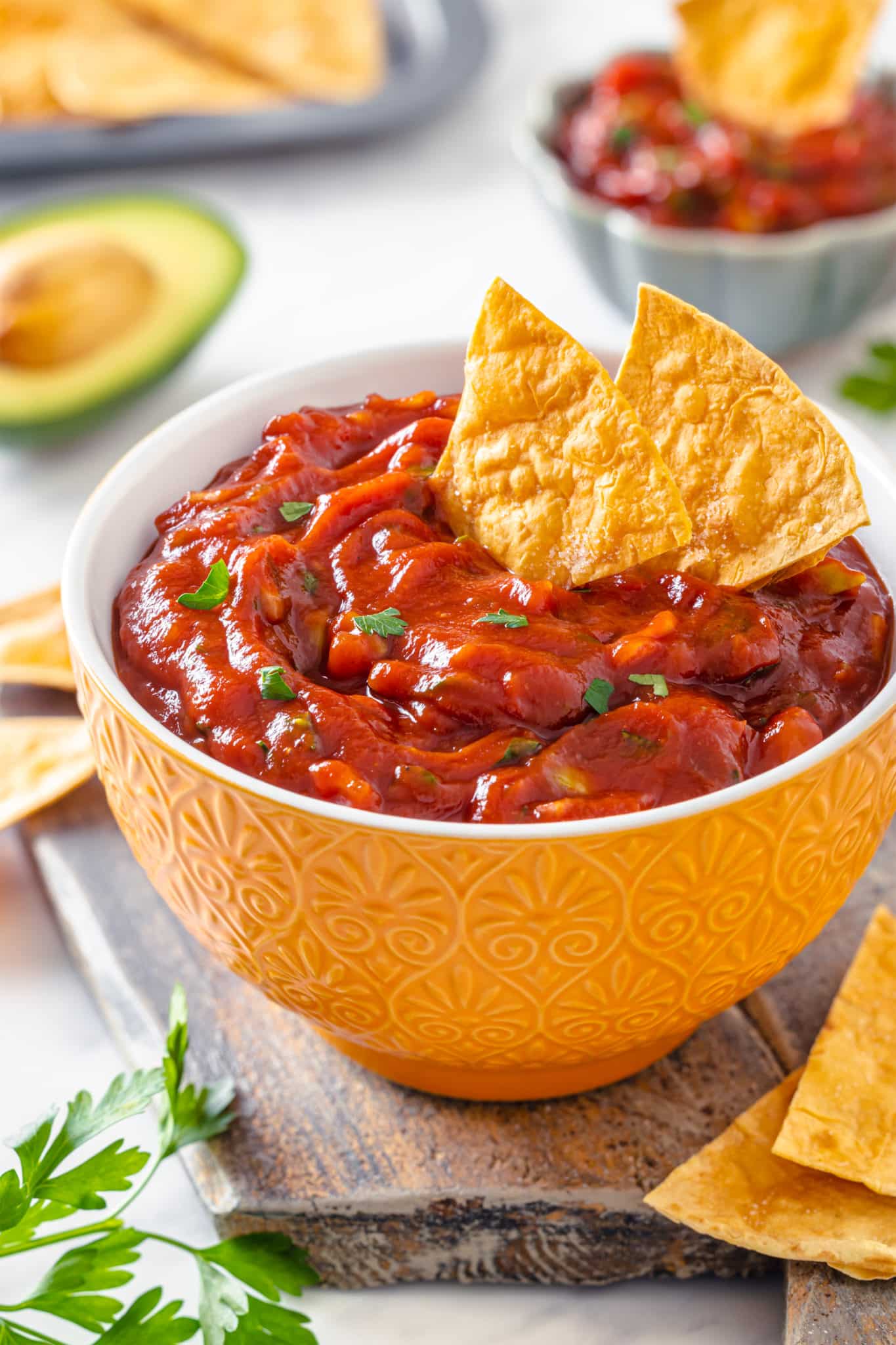 a bowl of avocado salsa with chips in the salsa.