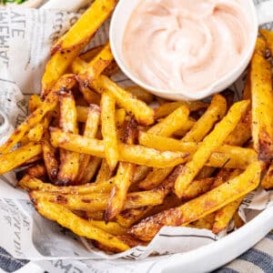 Sauce in a white bowl serving with roasted fries.