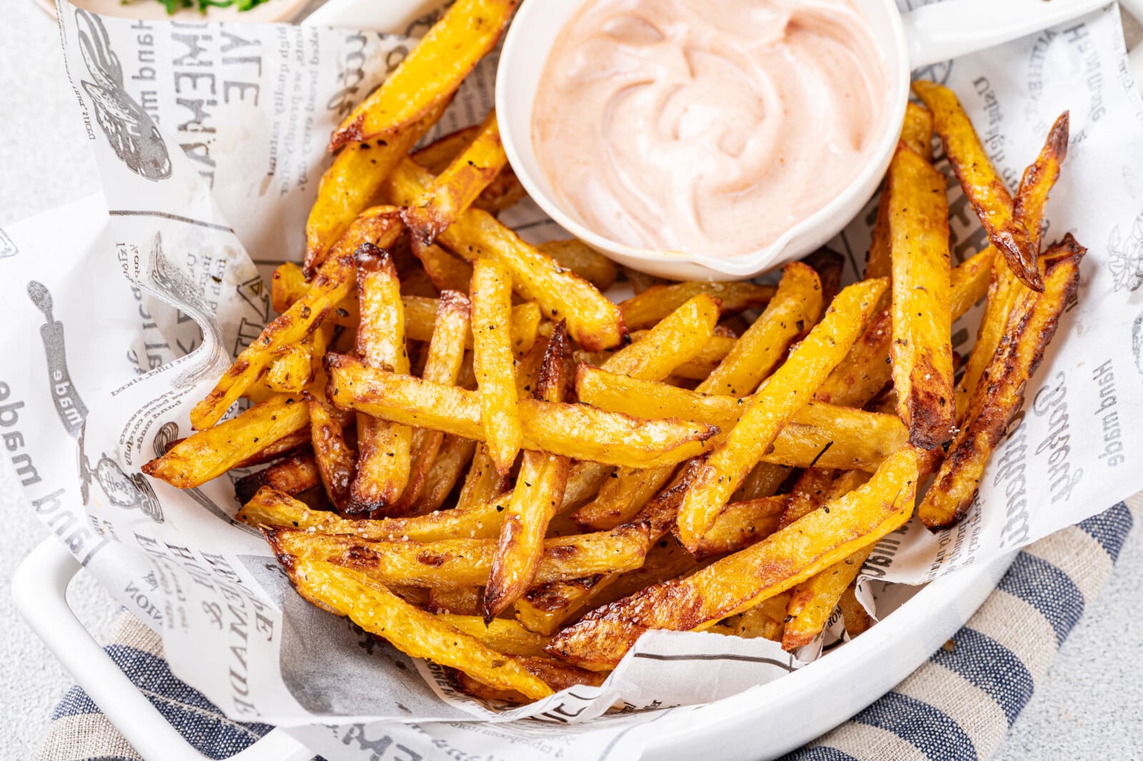 Sauce in a white bowl serving with roasted fries.