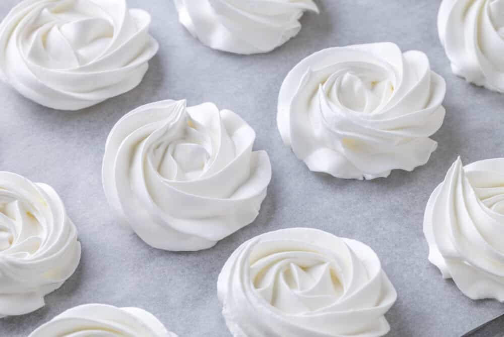 Close up of freshly piped marshmallows on a tray.