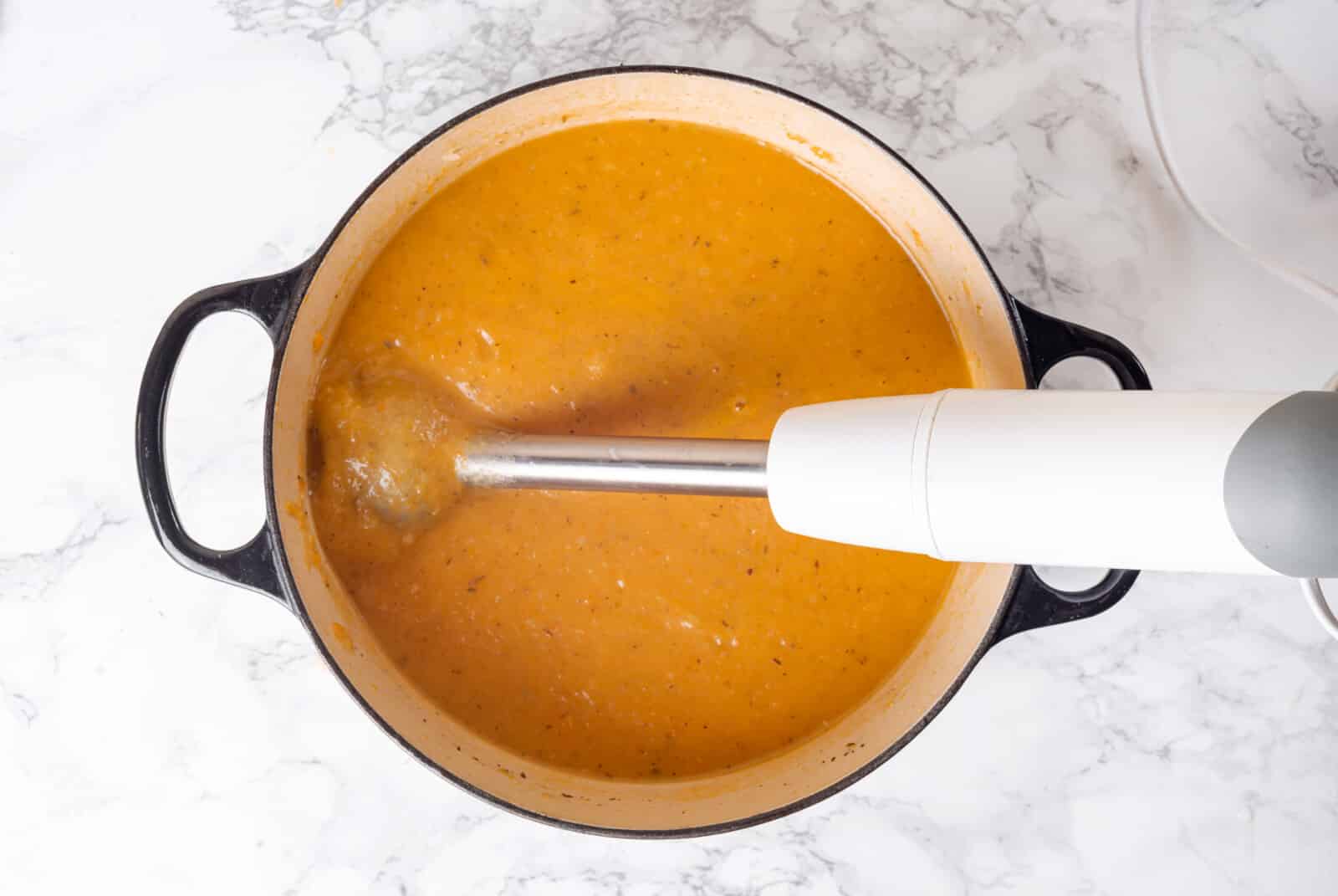 Immersion blender blending winter squash soup.