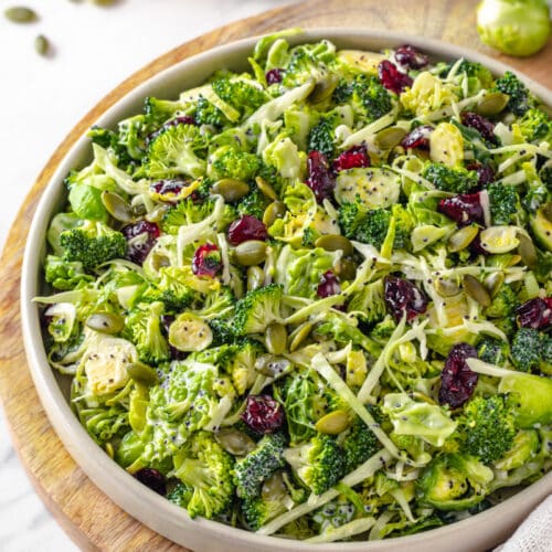 pumpkin seeds, broccoli, Brussels sprouts, and died cranberry with romaine lettuce in a bowl tossed with poppy seed dressing.