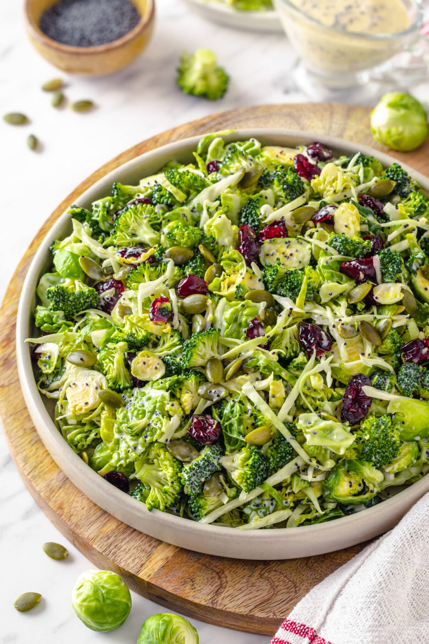 pumpkin seeds, broccoli, Brussels sprouts, and died cranberry with romaine lettuce in a bowl tossed with poppy seed dressing.