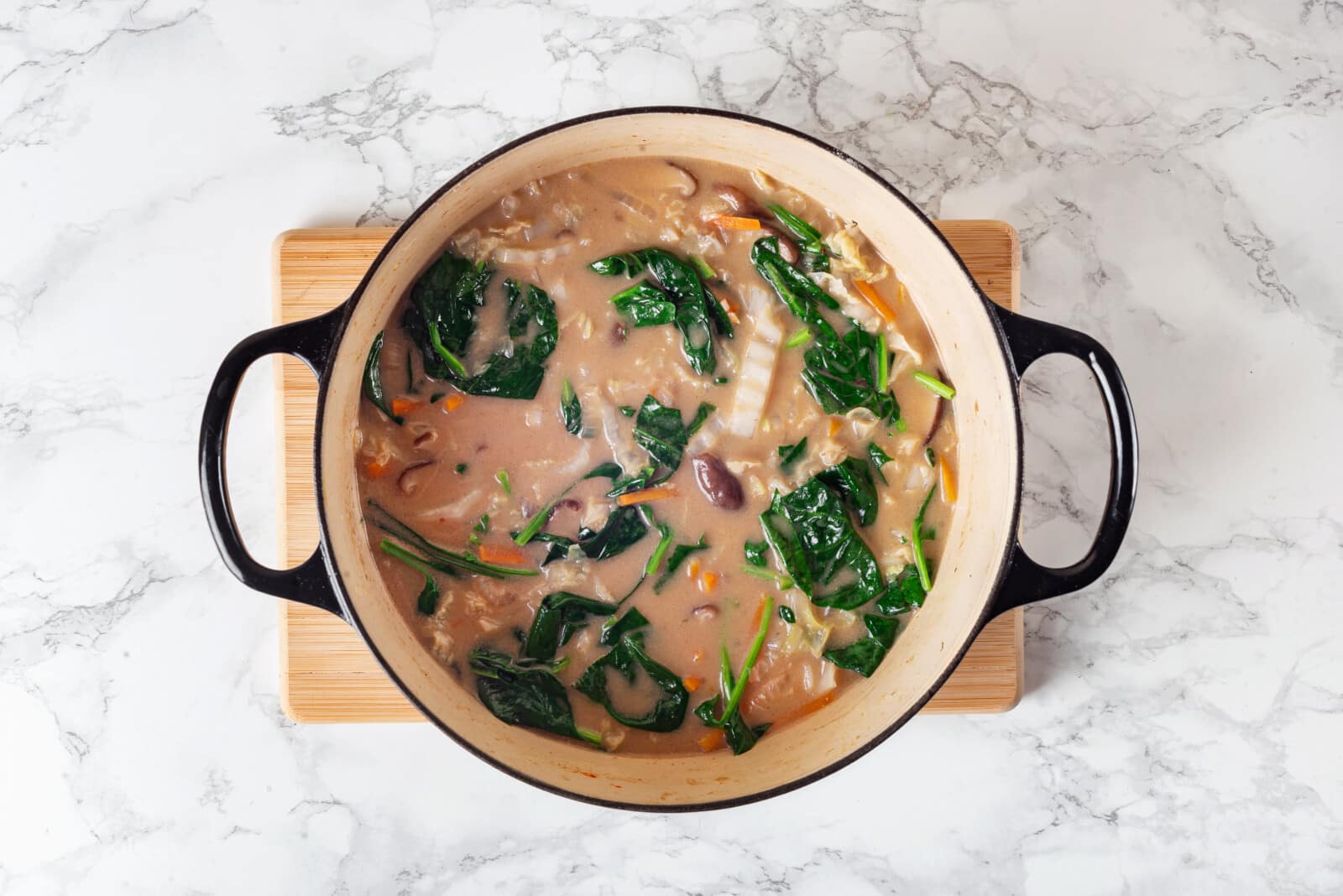 Thai coconut vegetable soup cooking in a soup pot.