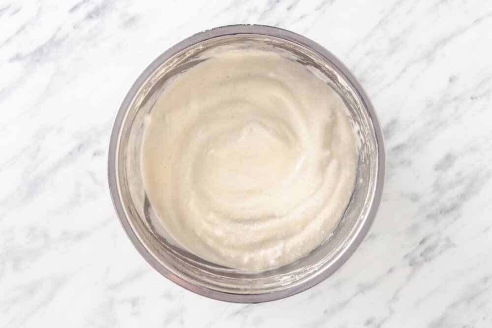 Tiramisu cake batter in a silver mixing bowl.