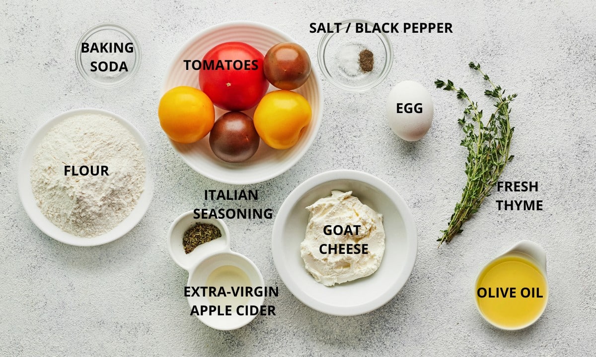 tomato galette recipe ingredients with labels goat cheese heirloom tomatoes Italian seasoning fresh thyme olive oil salt and egg.