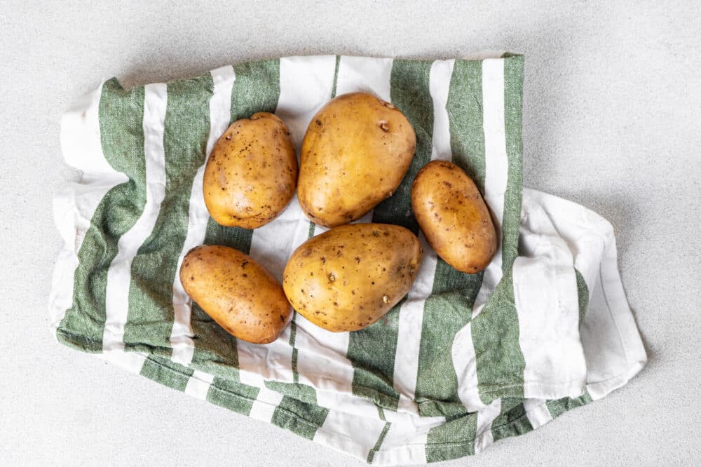 Washed potatoes with a striped towel.