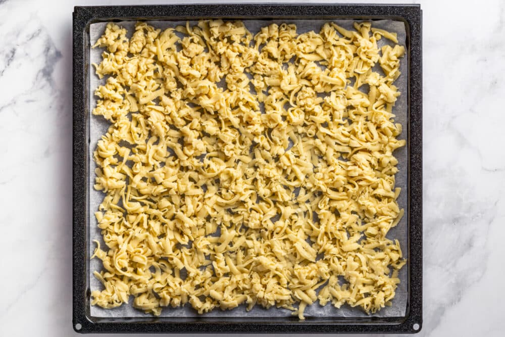 Raw dough grated onto a baking sheet.