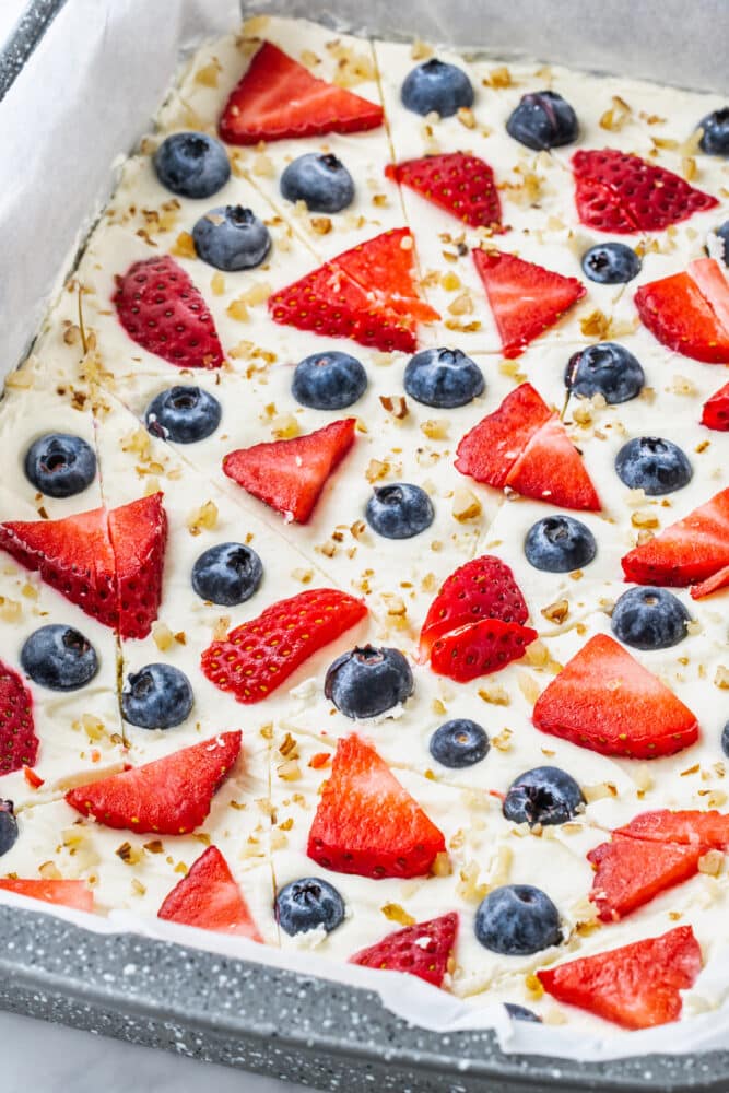 frozen yogurt bark in a pan cut up into random pieces.